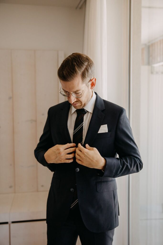Mario knöpft beim Getting Ready sein Sakko zu