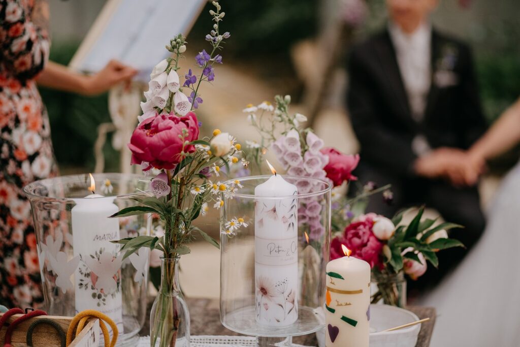 Trautisch mit Kerze und pinken Bio-Blumen bei der Zeremonie