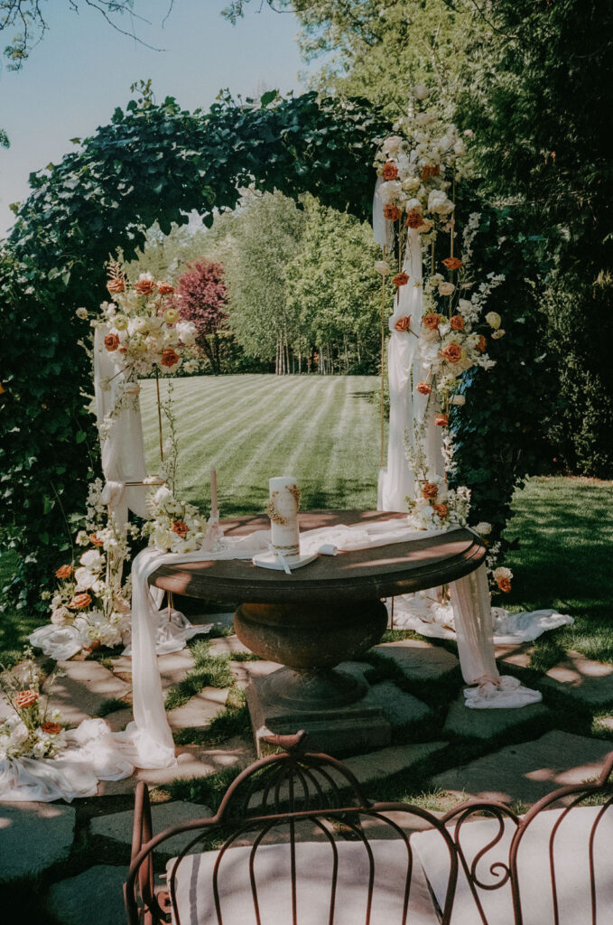 Blumengeschmückter Traubogen bei freier Trauung im Garten des Aiola im Schloss St. Veit – analoger Filmlook auf Portra 400.