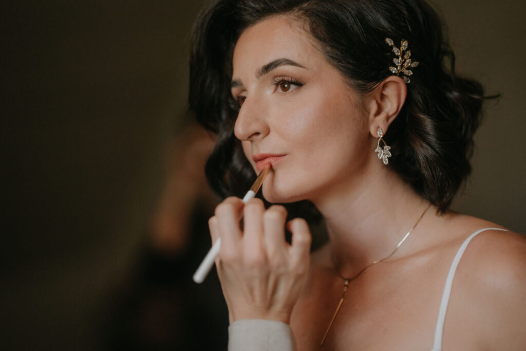 Nahaufnahme des Braut-Make-ups beim Auftragen von Lippenstift.