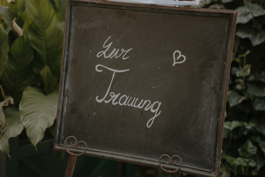 Handgeschriebenes Schild „Zur Trauung“ auf Tafel – Hochzeit Aiola Steiermark