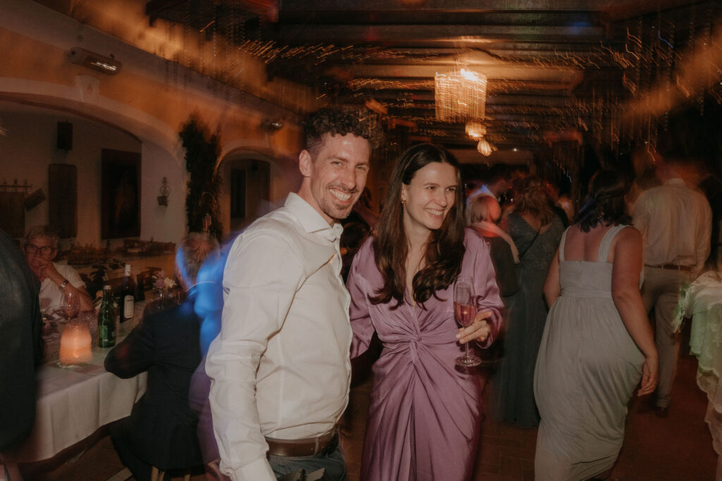 Ausgelassene Stimmung bei der Hochzeitsfeier, das Brautpaar tanzt im Kreise ihrer Familie und Freunde.