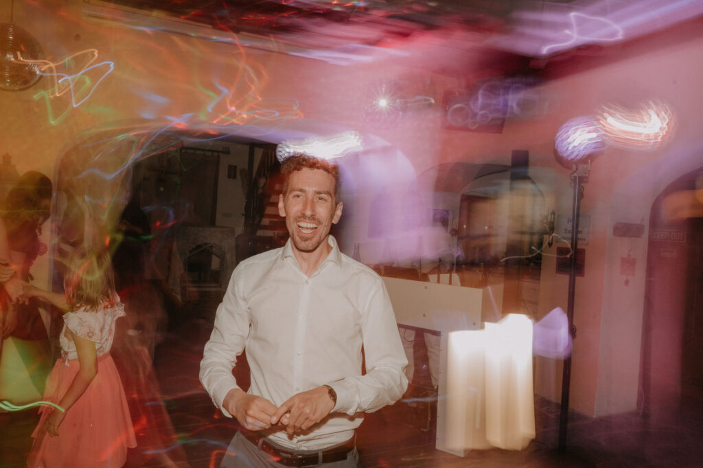 Ausgelassene Stimmung bei der Hochzeitsfeier, das Brautpaar tanzt im Kreise ihrer Familie und Freunde