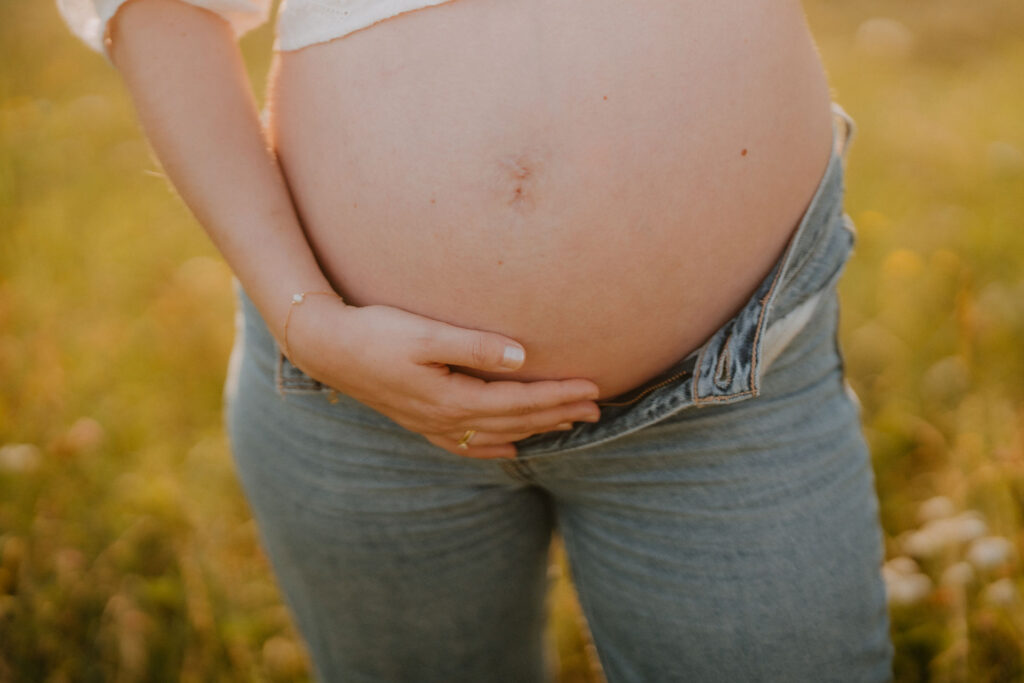 Detailaufnahme vom Babybauch in natürlichem Licht
