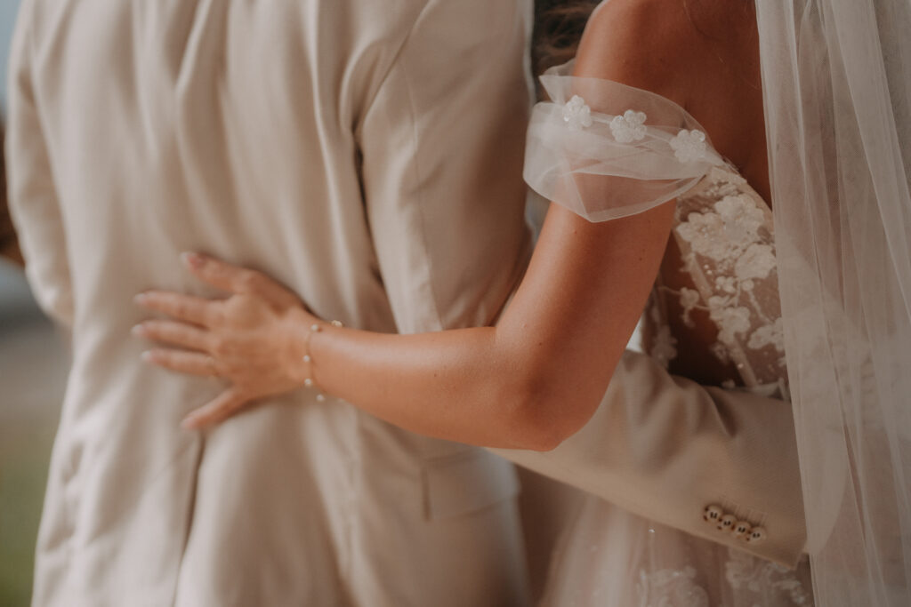 Detailaufnahme von Braut und Bräutigam beim Umarmen – natürliche und gefühlvolle Hochzeitsfotografie in der Steiermark