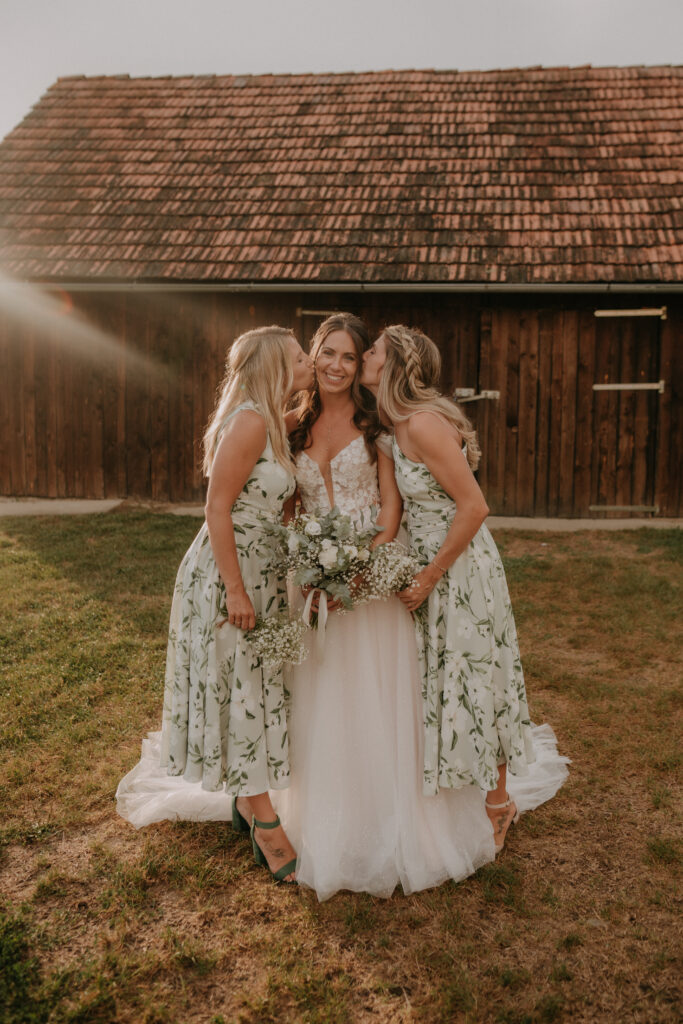 Braut mit zwei Brautjungfern in floralen Kleidern beim Sonnenuntergang – natürliche und authentische Hochzeitsfotografie in der Steiermark
