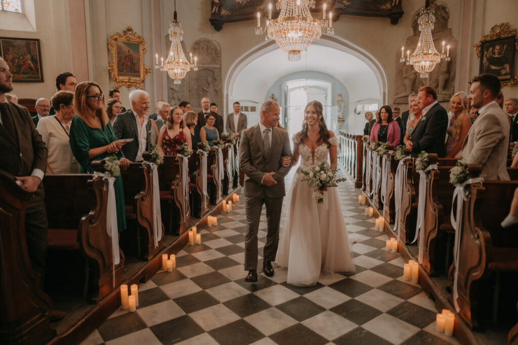 Braut wird vom Vater zum Altar geführt – emotionale Hochzeitsfotografie in der Kirche in der Steiermark