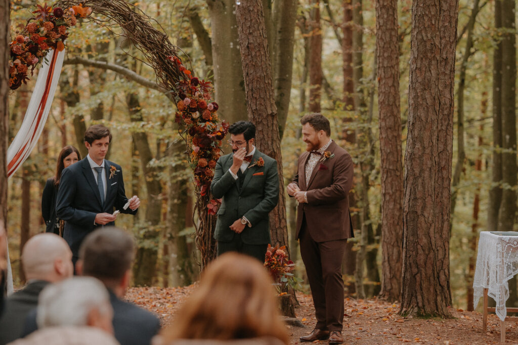 Der Bräutigam wischt sich gerührt eine Träne aus dem Gesicht, während ein Trauzeuge neben ihm steht.