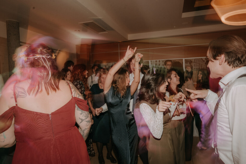Hochzeitsgäste tanzen ausgelassen auf der Party, stimmungsvolle Bewegungsunschärfe und fröhliche Atmosphäre bei der Waldhochzeit in der Steiermark.