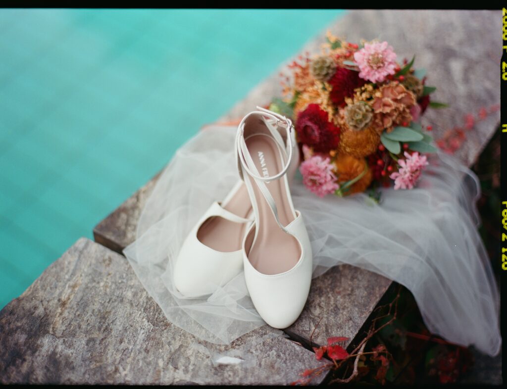 Brautschuhe und Blumenstrauß als Hochzeitsdetail fotografiert