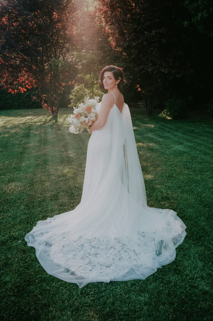 Brautportrait im Garten mit Brautkleid und Blumenstrauß bei der Hochzeitslocation Aiola Schloss St. Veit