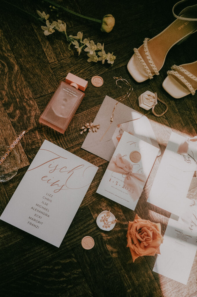 Hochzeitsdetails Flatlay mit Papeterie, Schmuck und Brautschuhen