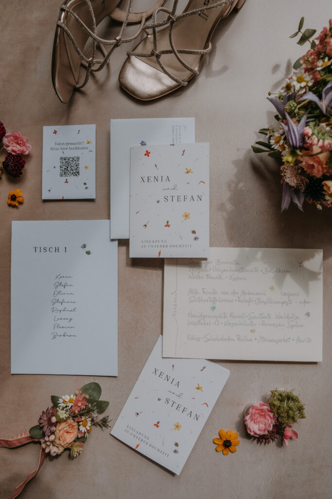 Hochzeitsdetails mit Einladung, Schmuck und Blumen
