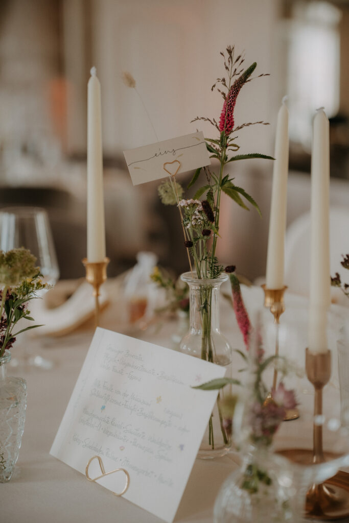 Hochzeitsdetails mit Einladung, Schmuck und Blumen
