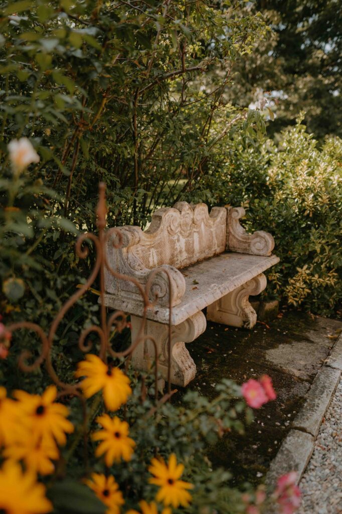 Vintage Gartenbank mit Sommerblumen im Schloss Ottersbach – Hochzeitslocation Steiermark