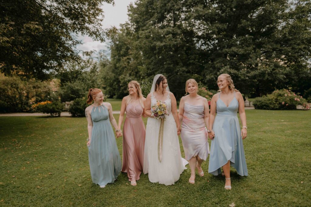 Braut mit Brautjungfern in Pastellkleidern im Schlosspark Ottersbach – natürliche Hochzeitsfotos Steiermark