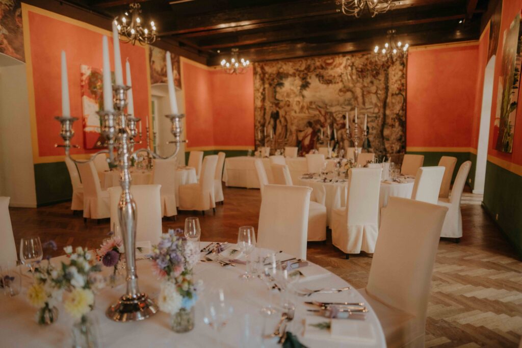 Festlich gedeckter Saal im Schloss Ottersbach mit Kerzenleuchtern und Blumendeko – Hochzeit Steiermark