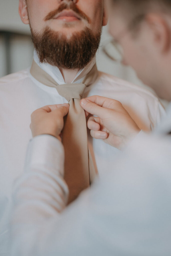 Bräutigam bindet sich die Krawatte – Getting Ready Hochzeit Graz
