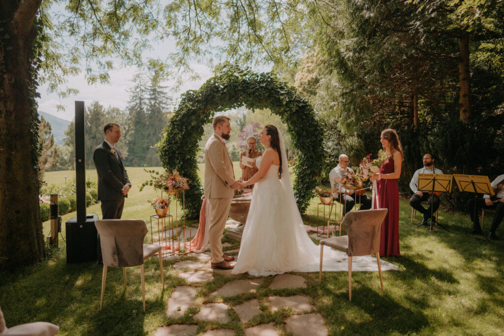 Brautpaar vor rundem Efeubogen – Hochzeit Aiola Graz