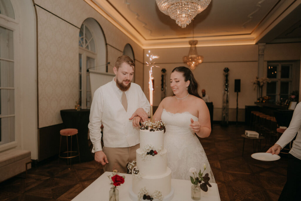 Brautpaar schneidet Hochzeitstorte mit Wunderkerze – Aiola im Schloss Graz
