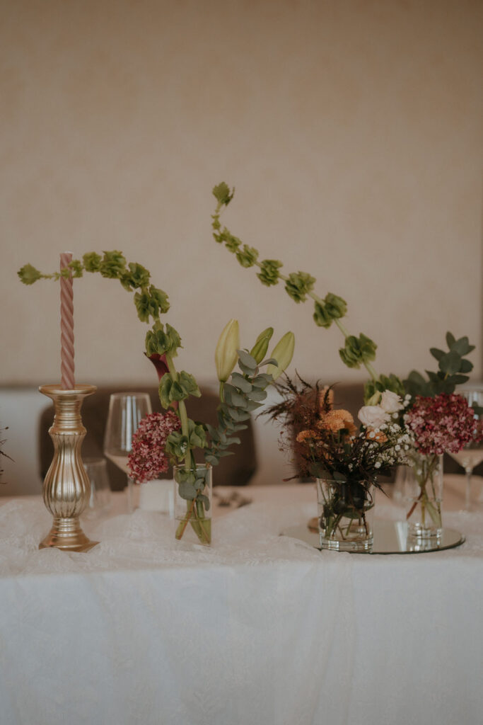 Tischdeko mit rosa Stabkerzen, Eukalyptus und Blüten