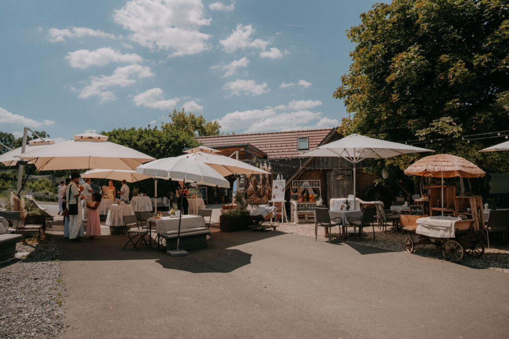 Außenbereich des Obstbau Haas mit Lounge-Möbeln und Sonnenschirmen