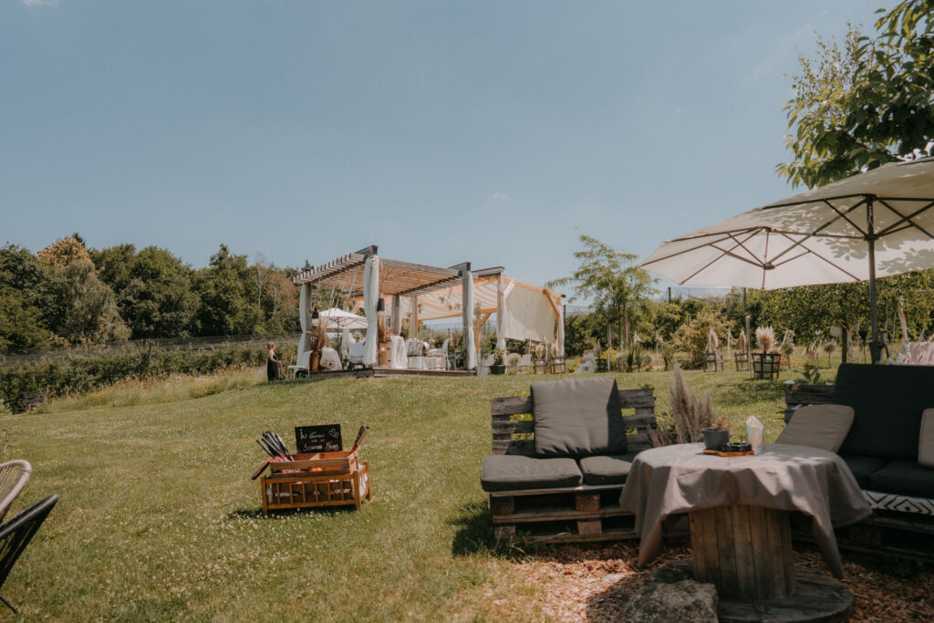 Freiluft-Pergola mit Lounge-Sitzgelegenheiten für die Hochzeitsfeier