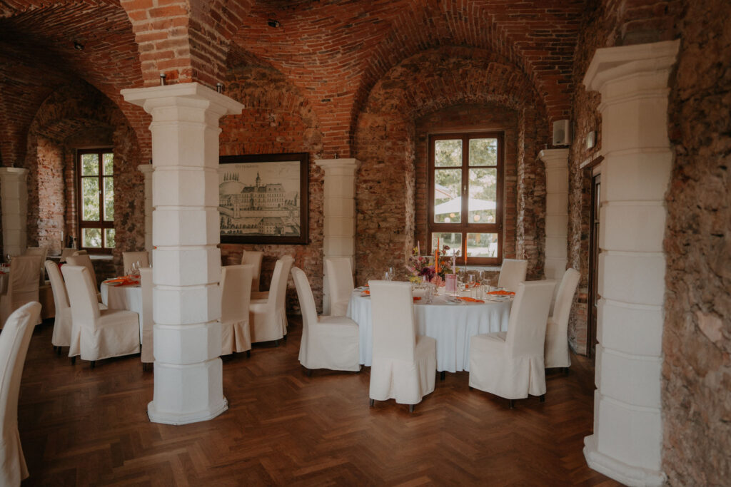 Festlich gedeckter Tisch im rustikalen Backstein-Gewölbe von Schloss Ottersbach für die Hochzeitsfeier