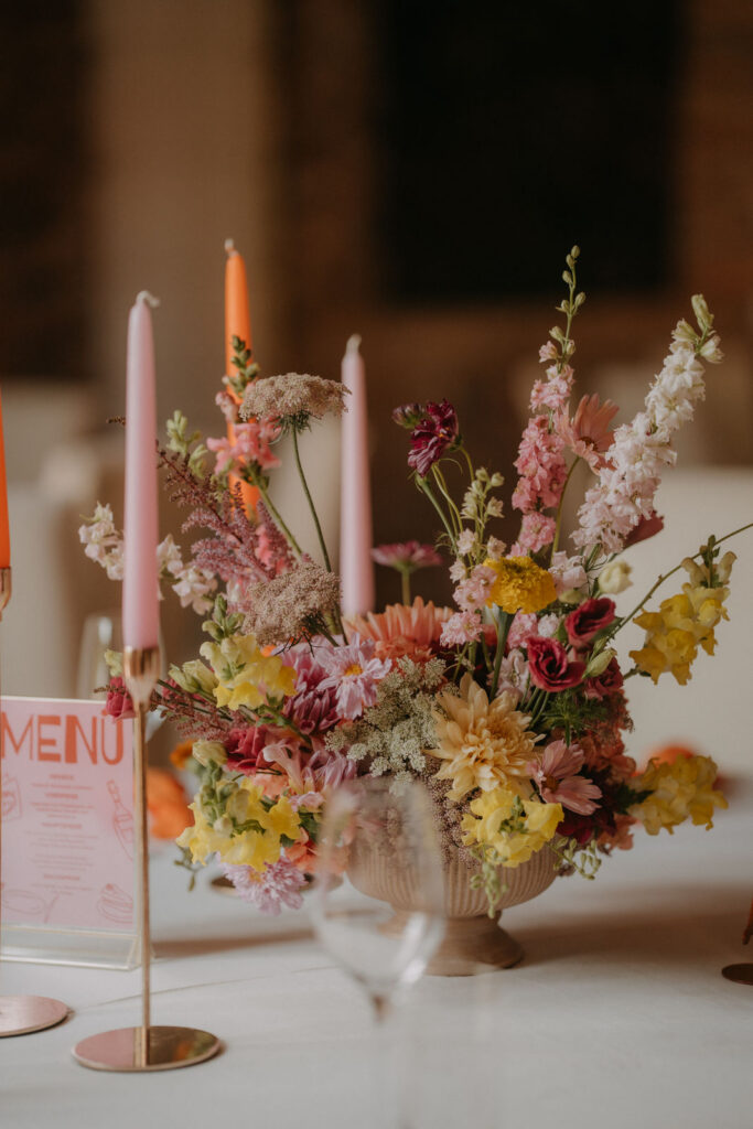 Bunte Tischdekoration mit Blumen, Kerzen und Menükarte bei der Hochzeit auf Schloss Ottersbach