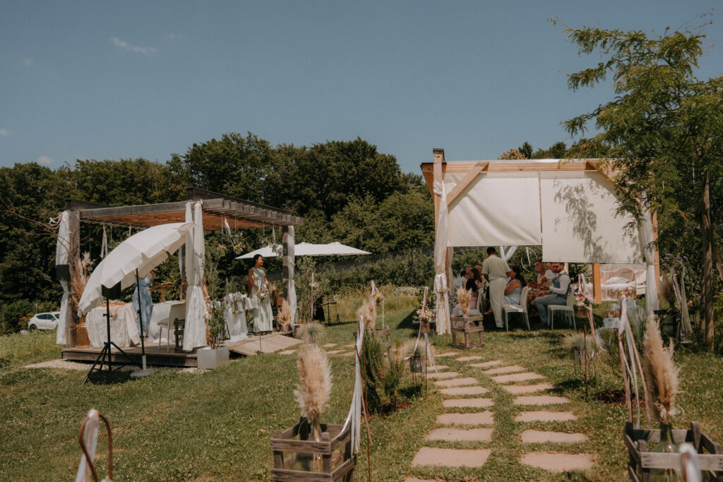 Weitwinkelaufnahme der Zeremoniepergola mit Gang zwischen Wildblumenwiesen