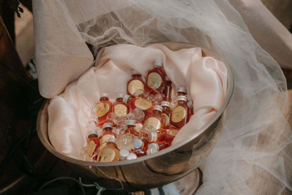 Detailaufnahme von Erdbeer-Bowle-Fläschchen als Gastgeschenk im Eisbad
