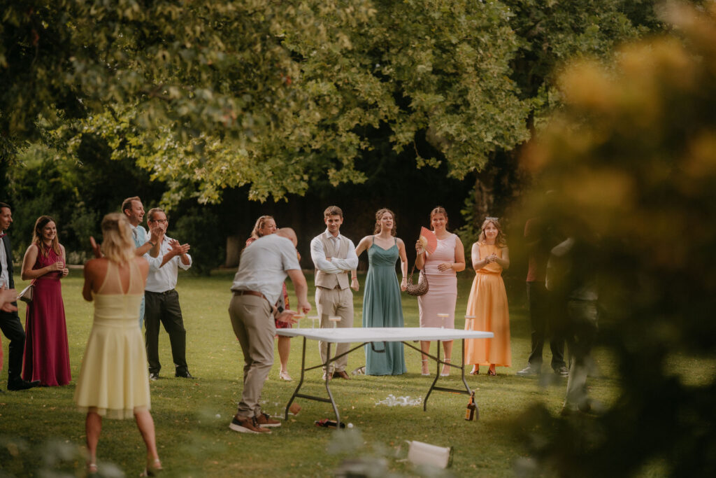 Hochzeitsgäste spielen gemeinsam ein Wurfspiel auf der Wiese von Schloss Ottersbach