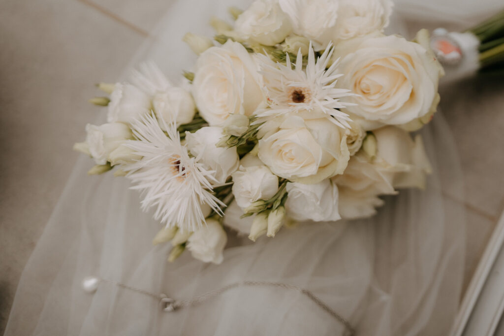 Brautstrauß aus weißen Rosen auf dem Schleier